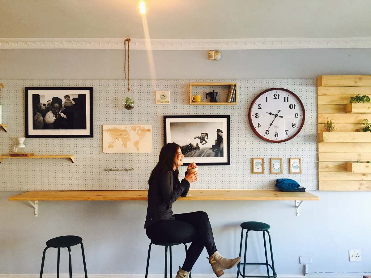 bar stool woman sitting on stall near wall mounted desk furniture